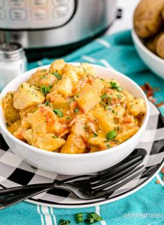 a white bowl filled with pasta and potatoes next to an instant pressure cooker in the background