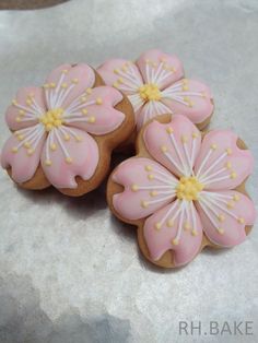 three cookies decorated with pink and yellow flowers