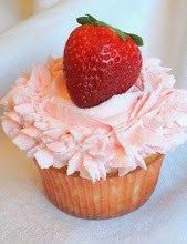 a cupcake with pink frosting and a strawberry on top