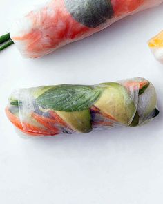 three different types of food wrapped in cellophane and sitting on a white surface