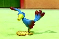 a toy bird is standing on top of a corn cob