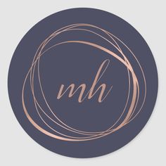 a round sticker with the letter nbh in gold on a dark blue background