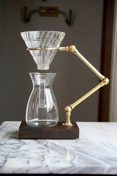 a glass coffee pot with a wooden base