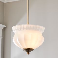 a light fixture hanging from the ceiling in a room with white walls and trimmings