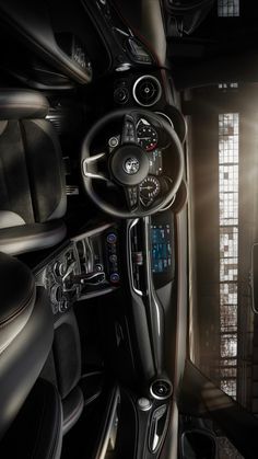 the interior of a car with black leather and silver trims, including steering wheel