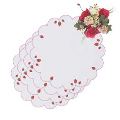 a bunch of paper with some flowers on top of it and red roses in the middle