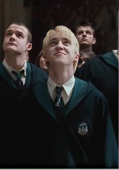 two young men with blonde hair are standing in front of an audience wearing harry potter robes