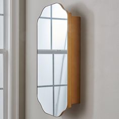 a mirror hanging on the wall next to a window