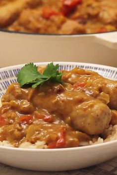 two bowls filled with rice and meat covered in gravy