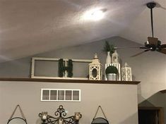 a living room filled with furniture and decor on top of a shelf above a fireplace