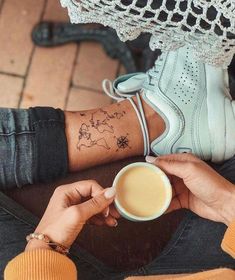 a person with a tattoo on their arm holding a coffee cup