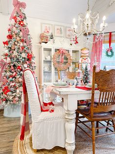 a christmas tree is in the corner of a room with chairs and a dining table