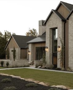 a house that is made out of stone and has grass in front of the windows