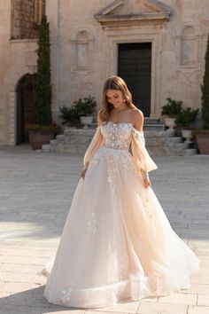 a woman in a wedding dress standing outside