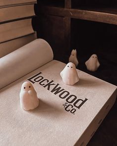 three small white birds sitting on top of a book