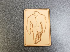 a wooden sticker with a drawing of a man's torso