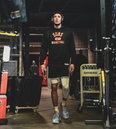 a man with headphones and knee braces walking through a warehouse