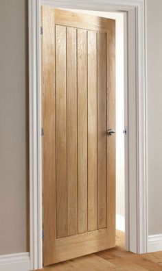 an open wooden door in a room with hard wood flooring and white trim on the walls