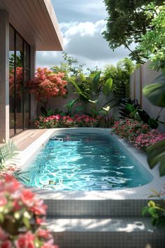 an empty swimming pool surrounded by lush green plants and pink flowers on either side of the pool