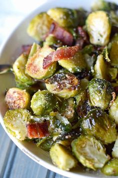 a white bowl filled with brussel sprouts and bacon