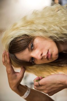 a woman with long blonde hair is posing for the camera