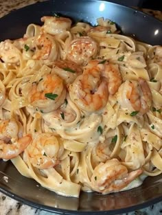 pasta with shrimp and sauce in a pan on the counter top, ready to be eaten