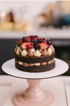 a chocolate cake topped with berries and other toppings