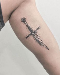 a knife tattoo on the right arm