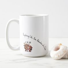 a couple of doughnuts sitting next to a coffee mug