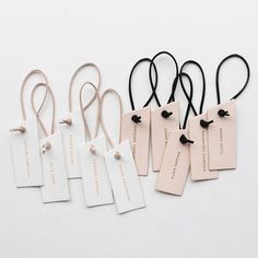 five tags with black string attached to them