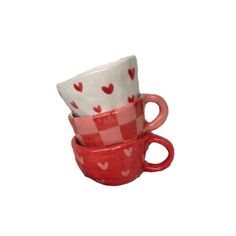 three red and white cups with hearts on them are stacked in the shape of mugs