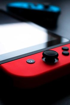 a red nintendo wii game controller sitting on top of a table