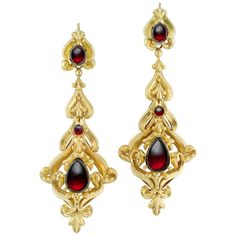 A pair of mid-Victorian garnet and gold earrings, each earring with an ornate scrolled mount, set with and oval, a round and a pear-shaped cabochon garnets, with gold wire fittings, all mounted in 15 carat gold, bearing French Assay marks, circa 1850, measuring 7.4cm long, gross weight 13 grams. Should you choose to make this purchase we will delighted to send it to you in a Bentley & Skinner handmade leather case packed in a gift-wrapped Bentley & Skinner black and gold presentation box. Shortl Garnet And Gold, Victorian Gold, Garnet Jewelry, Jewellery Shop, Topaz Earrings, Diamond Drop Earrings, Bespoke Jewellery, Gold Earring, Lovely Jewellery