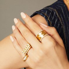 a woman's hand with two rings on her fingers and one ring in the middle