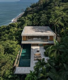 an aerial view of a house in the middle of trees and water with a pool