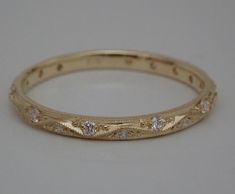 a gold wedding band with diamonds on it