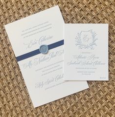 the wedding stationery is laid out on top of each other, with a blue ribbon