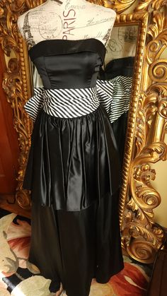 "This beautiful prom dress is from the 80's by Jessica Mc Clintock.  This is a high quality gown in excellent condition!  Made of lucious black satin with a wide striped cumberbund waist. Beautiful large bow on the back that secures with a snap on one side. Strapless style with a wide cuff around the top.  Fitted bodice with boning for stability. Tired skirt.  There is an under layer with tulle at the bottom for shape.  It is labeled a size 7, however, it fits smaller through the bust. Please see the measurements below for a proper fit.  All sales are final. Measurements Bust 30\" Waist 26\" Length from top of back 48\"" Jessica Mcclintock Wedding Dress, Tired Skirt, Beautiful Prom Dress, Fashion 1980s, 80s Prom Dress, Beautiful Prom Dresses, Polyester Pants, Jessica Mcclintock, 80s Dress