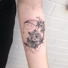 a woman's arm with a rose and crescent moon tattoo on the left forearm