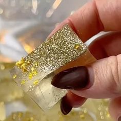 a woman's hand holding a piece of gold glitter