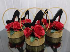 there are three pairs of high heel shoes with roses in the basket on the table