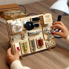 a woman is playing with an assortment of items in a wooden box on the table