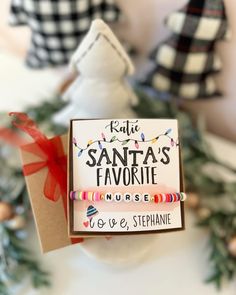 a christmas ornament with santa's favorite nurse bracelets and a card