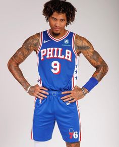 a man in a philadelphia 76 jersey is posing for the camera with his hands on his hips