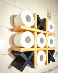 several rolls of toilet paper are stacked up on a shelf in front of a tiled wall