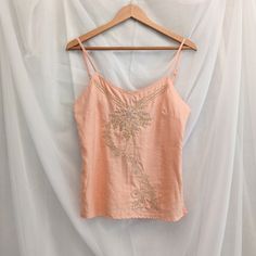 "Richard Malcolm linen peach pink tank top. Has a side zipper and adjustable straps. The front is embroidered and beaded in gold and silver.  Flat Lay Measurements: 17.5\" bust, 16\" waist, 18\" hem, 23\" long" Gold Embellished Summer Top, Gold Sleeveless Summer Camisole, Sleeveless Gold Camisole For Summer, Gold Sleeveless Camisole For Summer, Gold Embellished Tops For Summer, Spring Embroidered Spaghetti Strap Tank Top, Embroidered Spaghetti Strap Tank Top For Spring, Gold Embroidered Top For Spring, Summer Embroidered Gold Tops