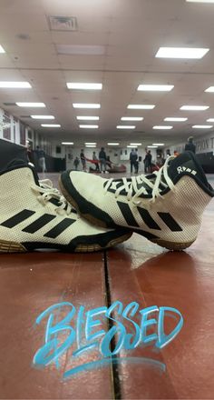 a pair of tennis shoes sitting on top of a hard wood floor in a gym