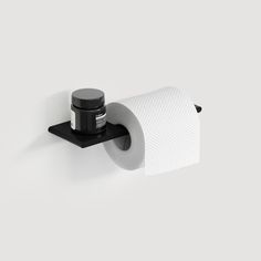 a roll of toilet paper sitting on top of a black holder