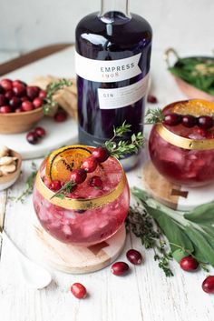 two glasses filled with cranberry shrub and garnish