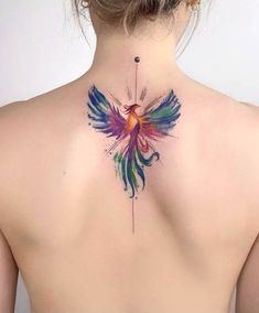 the back of a woman's neck has a colorful bird tattoo on it